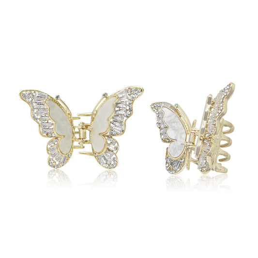 Butterfly-shaped hair clips with gold and crystal details on a white background