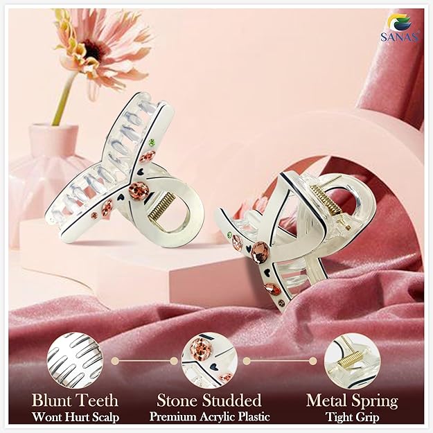 Hair clips with different design features on a pink fabric background, featuring the brand 'SANAS'.