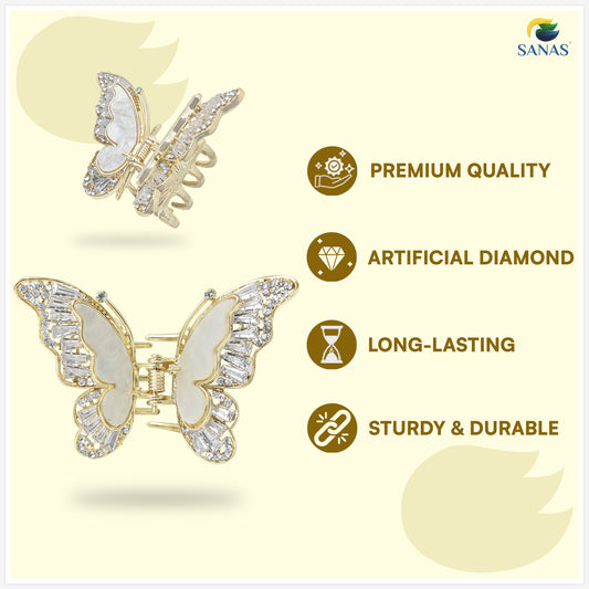 Butterfly-shaped hair clips with gold and white design on a light yellow background, featuring SANAS branding.