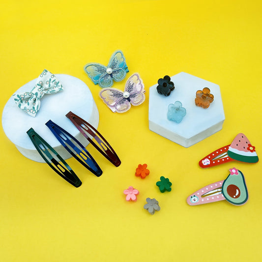 Cute baby hair accessories including butterfly clips, fruit tic-tac clips, bow pins, flower claw clips, and metal snap clips on display.