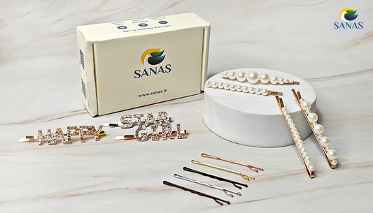 A stylish flat lay of SANAS bobby pins featuring rhinestone-studded word pins, pearl hair clips, and matte metallic finish pins in gold, rose gold, silver, and black—perfect for all hair types. Ideal hair accessories for women, girls, and bridal styling.