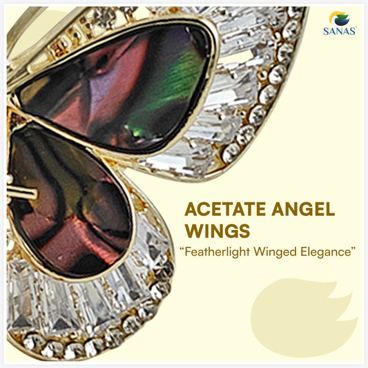 Gold and crystal sunglasses with 'Acetate Angel Wings' text on a light yellow background