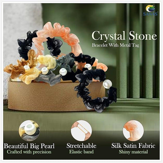 Set of crystal stone bracelets with metal tag on a green surface