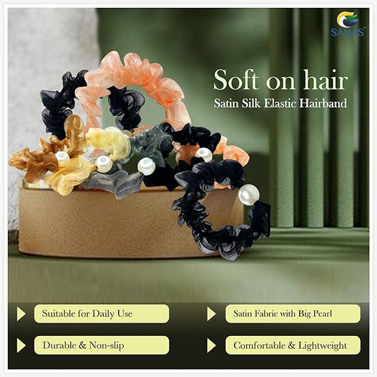 Satin silk elastic hairbands with pearls on a wooden stand against a neutral background -Elegant women’s scrunchies for stylish everyday hairstyles